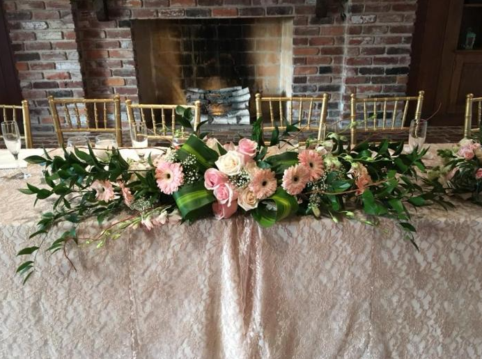 pink daisy floral arrangement on wedding reception table