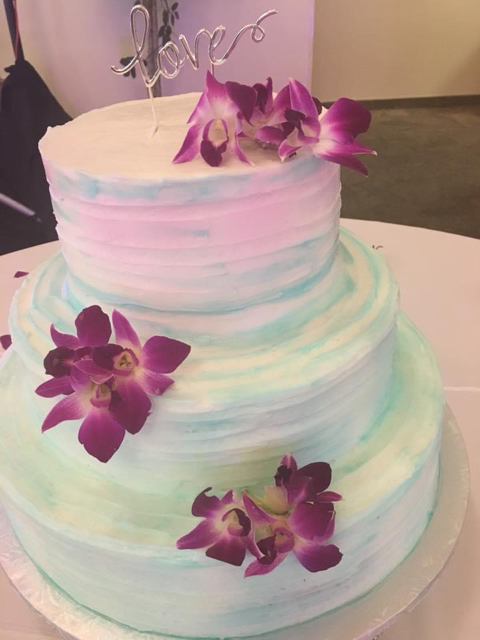 pastel wedding cake with purple tropical flowers