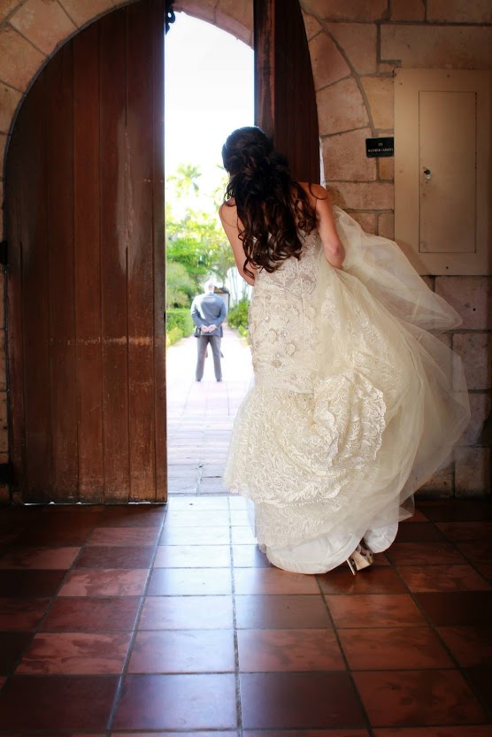 bride looking out door at groom